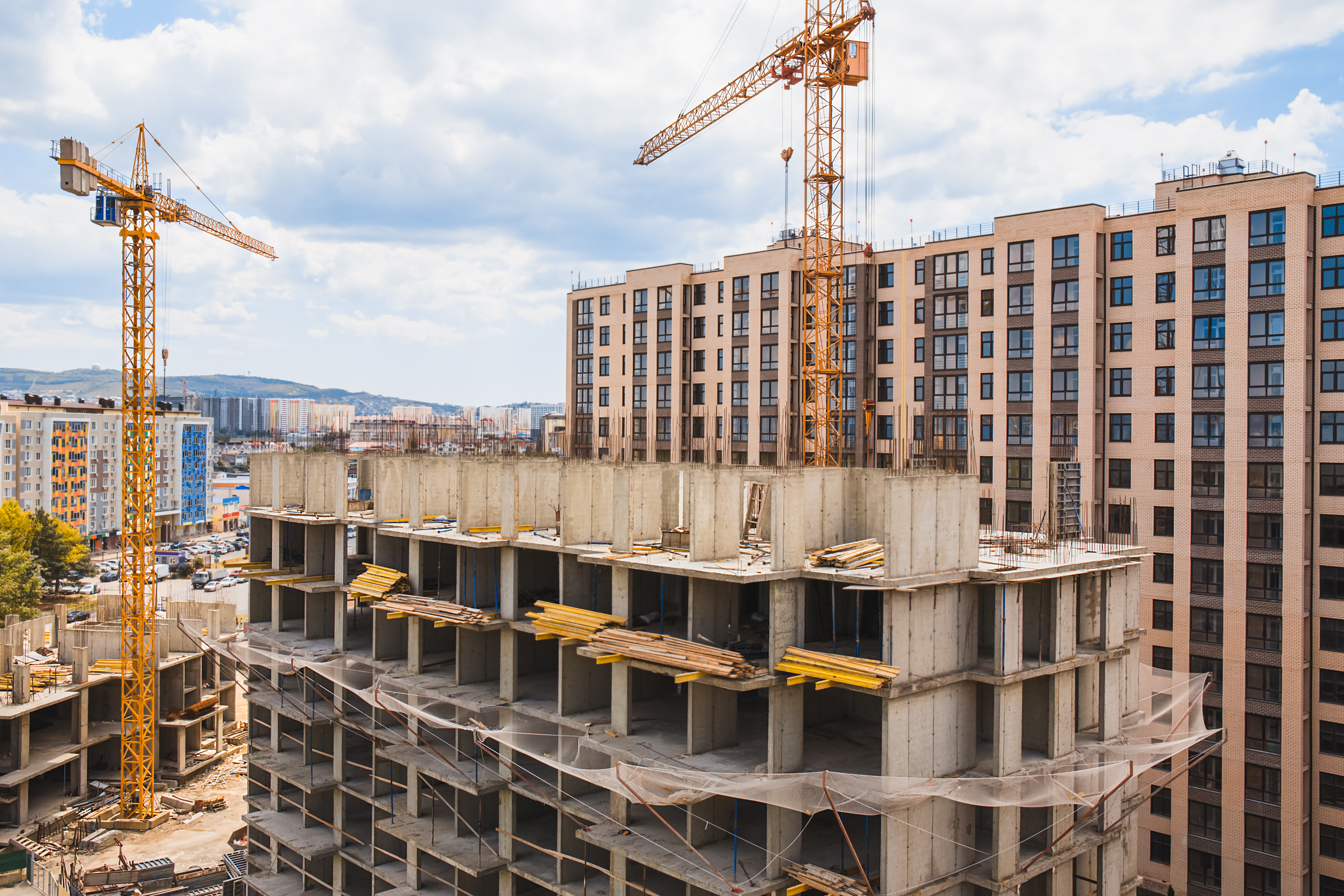 Modern construction site with cranes. Incomplete building construction